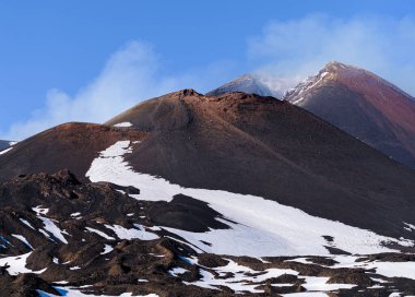 İtalya 'nın Sicilya kentinde kışın karla kaplı bir kalderada volkan dumanı tüten Etna Dağı' nın ay manzarası.