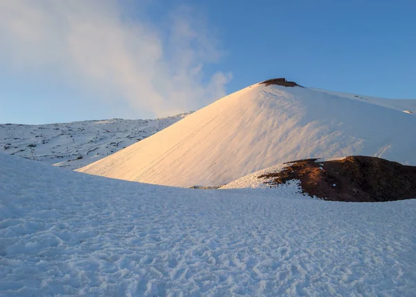 Snow covered landscape on Mount Etna volcano, with ski slope crater and melted snow field, near Catania, Sicily, Italy