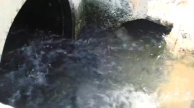 A muddy river with brown water. Slow current. A muddy river during a winter flood. dirty river. Dirty water of muddy river in flooding period during heavy rains in spring.