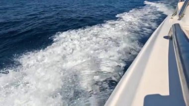 Sürat teknesi. Sürat teknesi güzel kızıl deniz suyunda yüzer. Ağır çekim. Bir jet ski denizin yüzeyinde koşuyor.. 