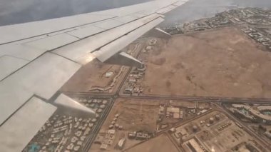 Uçak. Uçuş ve Seyahat, uçağın kanat penceresinden manzara. Ağır çekim. Uçak penceresinden bak. Kanatta uçarken cam uçağından bakıyor..