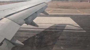Uçak. Uçuş ve Seyahat, uçağın kanat penceresinden manzara. Ağır çekim. Uçak penceresinden bak. Kanatta uçarken cam uçağından bakıyor..