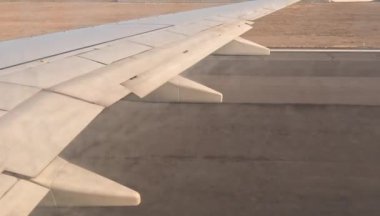 Uçak. Uçuş ve Seyahat, uçağın kanat penceresinden manzara. Ağır çekim. Uçak penceresinden bak. Kanatta uçarken cam uçağından bakıyor..