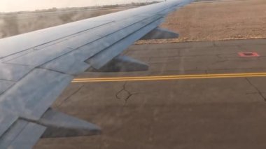 Uçak. Uçuş ve Seyahat, uçağın kanat penceresinden manzara. Ağır çekim. Uçak penceresinden bak. Kanatta uçarken cam uçağından bakıyor..