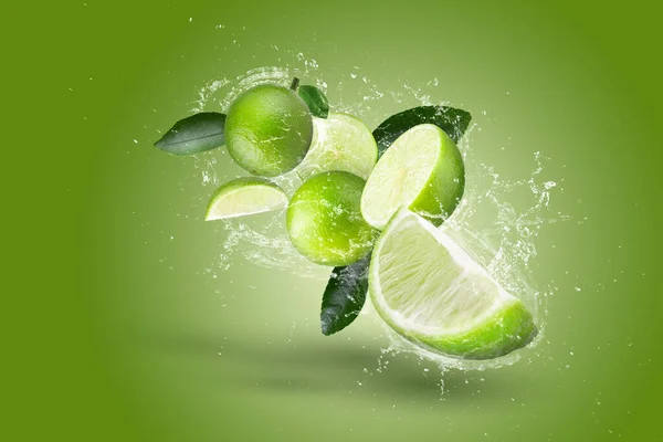 柠檬水溅在绿色柠檬水果隔离在绿色背景 — 图库照片