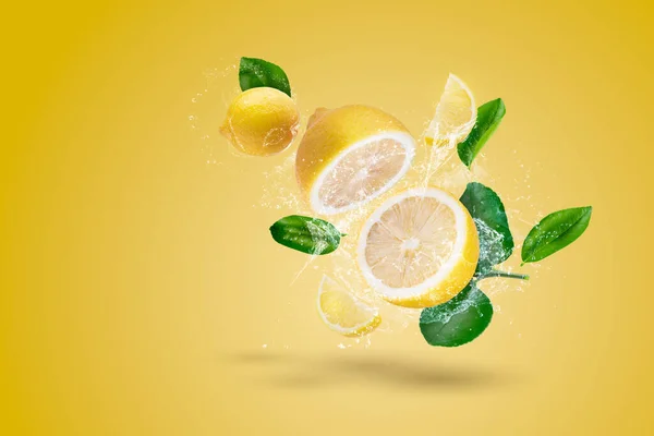 Wasserspritzer Und Gelbe Zitronenfrucht Auf Gelbem Hintergrund — Stockfoto