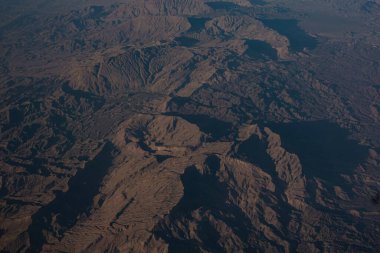Aerial view of an airplane flying above clouds and sky. View from the plane window.