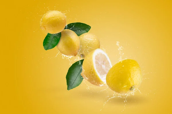 Water Splashing yellow lemon fruit on a yellow background.