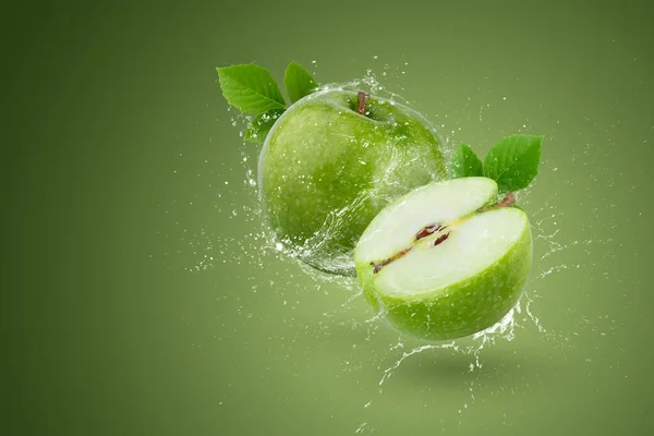 Creative layout made form whole and slice green apple and water splashing on a green background.