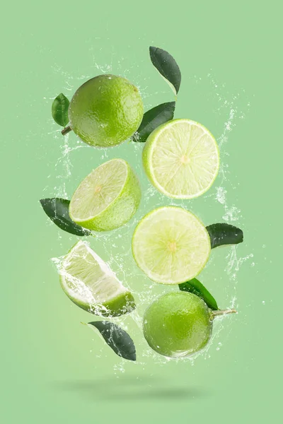 Creative layout made from green lime and green leaves on a pastel green background. Fruit minimal concept. Flat lay, top view, and copy space.