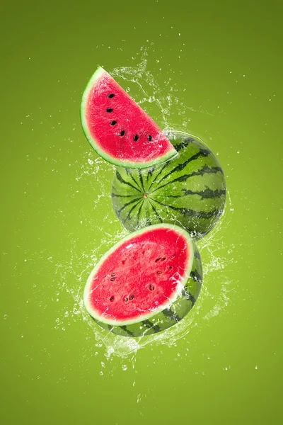 Wasser Spritzt Auf Aufgeschnittene Wassermelonenfrucht Isoliert Auf Grünem Hintergrund — Stockfoto