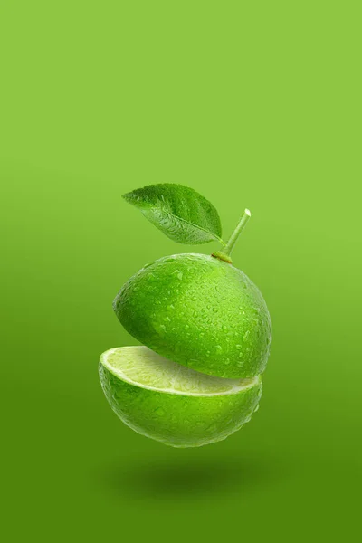 绿石灰水果和绿叶在绿色背景上隔离制成的创意布局 — 图库照片
