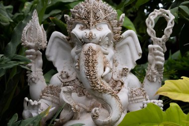 Tanrı Ganesha heykeli, ağaçlarla çevrili bir bahçeye yerleştirilmiş fil başlı Ganesh tanrısı..