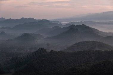 Yüksek dağlar, gün batımı manzaralı güzel bir gökyüzü ve bolca su buharı Ban Pang Puai vadisinde, Mae Moh, Lampang, Tayland 'da bir sis denizi yaratır..