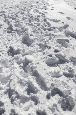 Kaldırımda çiğnenmiş kar, karda çiğnenmiş, karda yürümüş. Bir sürü açık ayakkabı izi var.