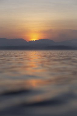 Nehir ve dağın güzel sabah manzarası dramatik bir gökyüzünde, günbatımının ve güneşin büyüsü, renklerin senfonisi - turuncu, kırmızı, mavi ve sarı, doğanın renkli bir ufku