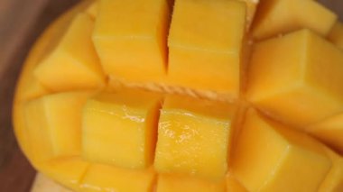 Yırtılmış mango dilimleri, yarım küp kesilmiş mango, taze sulu mango meyveleri.