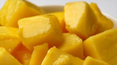 Yırtılmış mango dilimleri, yarım küp kesilmiş mango, taze sulu mango meyveleri.
