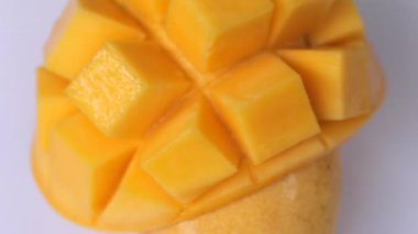 Yırtılmış mango dilimleri beyaz arkaplanda dönerek kesilir