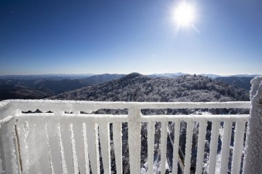 Balkon korkuluğu kar beyazı arka planda buzla kaplı. Kar yağışı sırasında balkondan görüntü. Seçici odak.