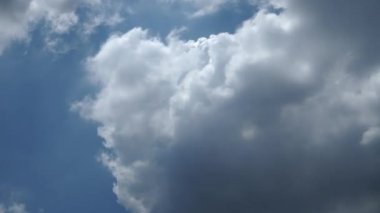 Beyaz bulutlu mavi bir gökyüzü parlak bir mavi tonla süslenir, kabarık beyaz bulutlarla süslenir..