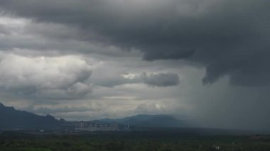 Zaman atlamalı dev fırtınalar Mae Moh kömür santrali ve göl üzerinde hızla ilerliyor. Boru soğutma kulesi endüstriyel beyaz buhar yayıyor doğal ortam karanlık bir gökyüzü ve büyük fırtına bulutları.