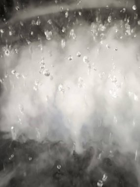 Arkaplan olarak su damlacıkları olan soyut bir beyaz buhar görüntüsü.
