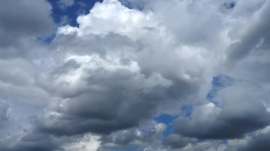 Mavi gökyüzünde dans eden tüylü, dramatik beyaz bulutların hızlandırılması