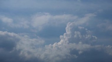 Mavi gökyüzünde dans eden tüylü, dramatik beyaz bulutların hızlandırılması