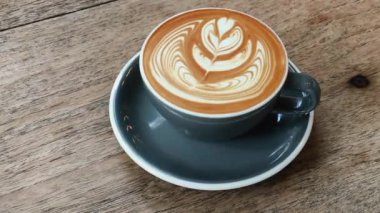 Kahve fincanları ve kapuçino latte tabloları. Masanın üstünde.