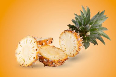 Turuncu arka planda izole edilmiş ananas dilimleri.