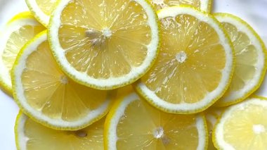 Parlak sarı ekşi limon dilimleri, taze dilimlenmiş limonlar güneş ışığında güzelce dizilmiş.