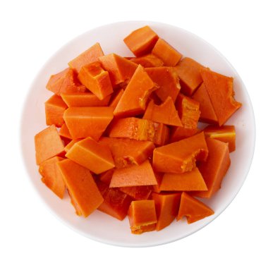 Yumuşak turuncu derili ve canlı etli olgun Hollanda papayası. Beyaz bir arka planda izole edilmiş beyaz bir seramik tabakta parçalara ayrılmış.