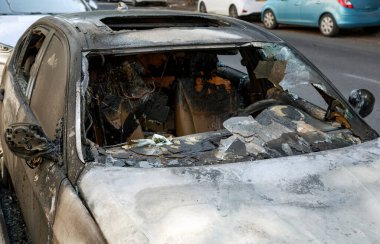 Terörist saldırısı. Patlamadan dolayı camlar kırılmış. Arabaları ateşe vermek. Yanmış bir arabanın kalıntıları. Caddenin ortasında, yol kenarında yanmış bir araba var. Yakılmış yeni araba, vandalizm, mafya.