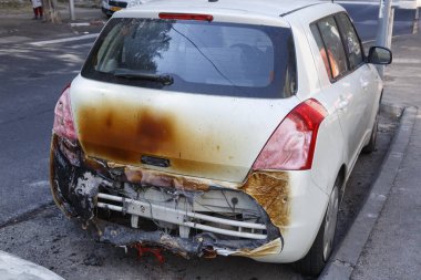 Sabahın köründe yanmış bir araba. Trafik kazasından sonraki sabah. Arabaları ateşe vermek, terörist saldırı, mafya. Yol kenarında yanmış bir arabanın kalıntıları var. Yanmış arabanın arka görüntüsü 