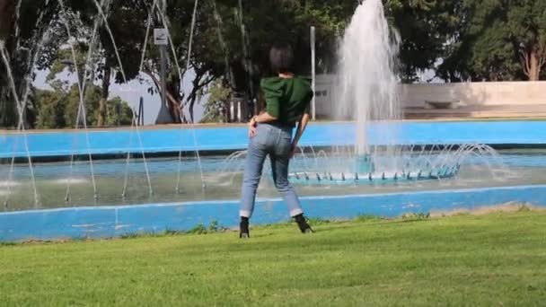 Радостная Брюнетка Солнечных Очках Зеленом Свитере Джинсах Весело Танцует Парке — стоковое видео