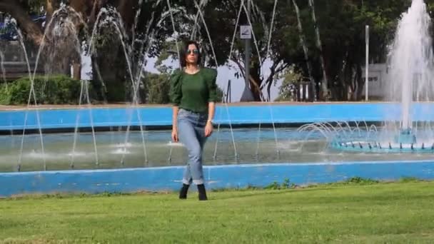Brunette Girl Sunglasses Dances Park Wearing Green Sweater Jeans Beaming — Stock Video