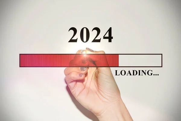Woman hand with glitter nails showing the Loading Bar with the new year 2024