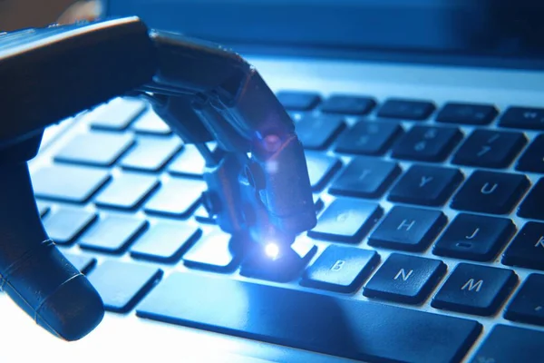 stock image Robotic hand typing on a keyboard . Concept of future and AI.