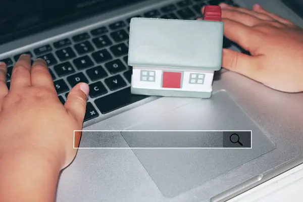 Child searching at the computer with a miniature house and a search bar . Care, health insurance, adoption, and family searching concept.