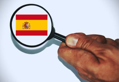 İspanyol Bayrağı 'nı gösteren bir büyüteç tutan el. .