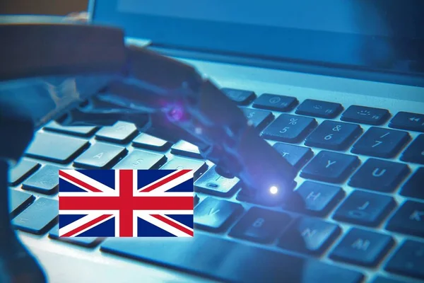 Robotic hand typing on a keyboard with the English Flag. Concept of future and AI in Great Britain.