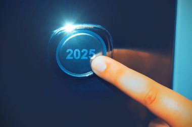 İnsan eli 2025 düğmesine basıyor. Yeni yıl kavramı..