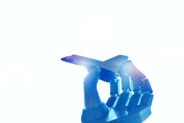 Metal çivili robot biyonik bir kolun yakın çekimi, arka plan olarak mavi gökyüzüne karşı mekiğin uçuşunu taklit eder. Seyahat hayali kavramı. Çivili Robotik El