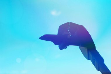 Metal çivili robot biyonik bir kolun yakın çekimi, arka plan olarak mavi gökyüzüne karşı mekiğin uçuşunu taklit eder. Seyahat hayali kavramı. Çivili Robotik El