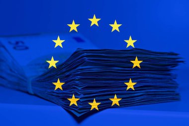 Arka planda Avrupa bayrağı bulunan 50 avroluk yığın masaya..