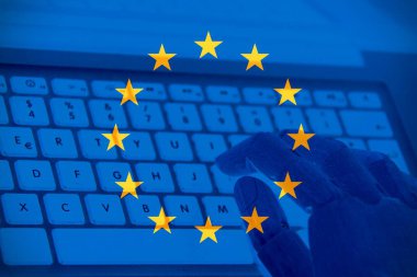 Avrupa Birliği bayrağı ve klavyede yazan bir robot el yazısı. Avrupa 'da Ai kavramı.