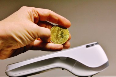 Müşteri terminalde NFC teknolojisini kullanarak bitcoin kripto para birimi ile ödeme yapıyor