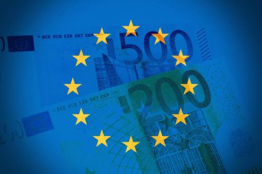 500 ve 200 avroluk banknot yığını, arka planda Avrupa bayrağı ile izole edilmiş..
