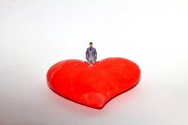 Kırmızı bir kalbe bakan bir adam.